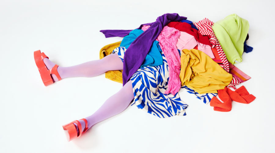 dziewczynka przygnieciona stosem ubrań